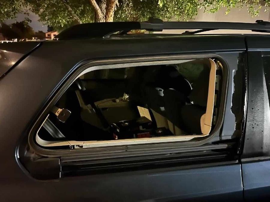 Toyota 4Runner rear quarter glass blown out by a monsoon storm, photographed at night before replacement